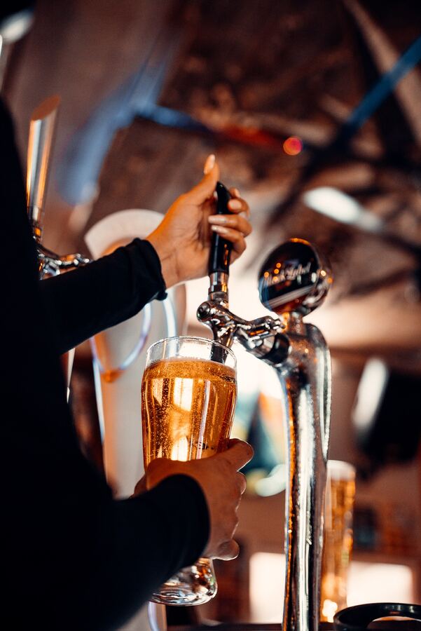 A beer being poured from the tap behind the bar